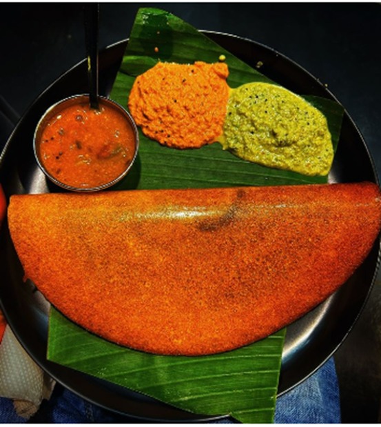 Crispy triangular dosa served with traditional chutneys and sambar